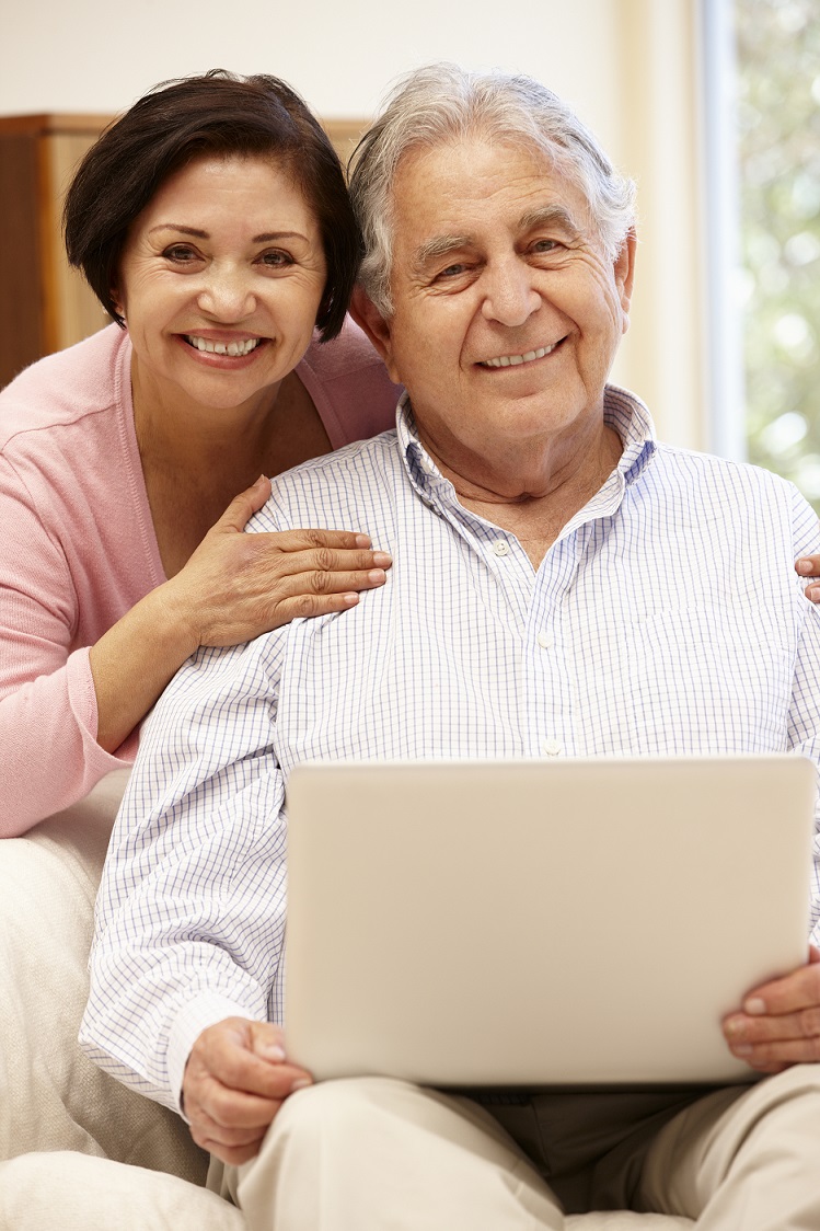 Image of a lady leaning over a gentlemen shoulder